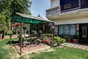 a patio with a table and chairs in front of a house at OYO Home Spacious Studio Sector 21-a Faridabad in Faridabad