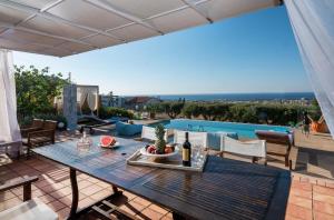 - une terrasse avec une table et une bouteille de vin dans l'établissement Villa Verde, à Mália