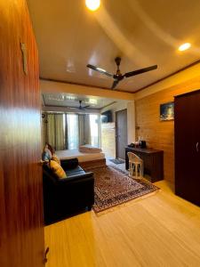 uma sala de estar com um sofá e uma cama em Tito's Homestay em Kalimpong