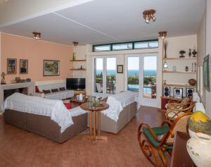 een woonkamer met 2 bedden en een open haard bij Villa Verde in Malia