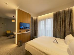 a hotel room with a bed and a flat screen tv at Holiday Inn Express - Ankara - Airport by IHG in Ankara