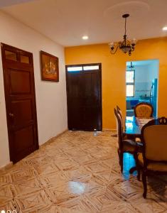 uma sala de jantar com uma mesa e cadeiras e uma porta em Casa Adiel em Campeche