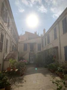an alley with buildings and plants and the sun in the sky at Joli Studio sur le Port in Cannes
