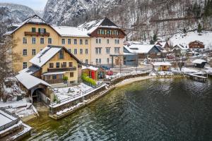 哈爾施塔特的住宿－Hallstatt Lakeside Top 2 - Zimmer mit Gartenzugang，积雪覆盖的建筑和水体的城镇