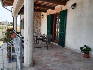 un patio con puertas verdes y una mesa con sillas en Il giglio perlato, en Marsciano