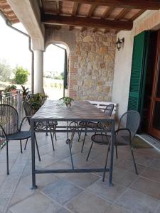 una mesa de madera y sillas en un patio en Il giglio perlato, en Marsciano