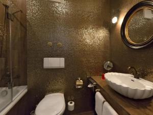 ein Badezimmer mit Waschbecken, Toilette und Spiegel in der Unterkunft DORMERO Hotel München-Kirchheim Messe in Kirchheim