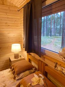 1 dormitorio con ventana en una cabaña de madera en Kempings Bejas, en Babīte