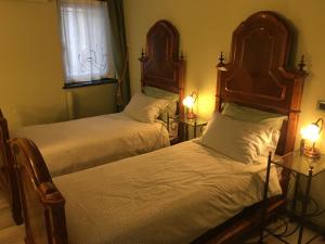 2 camas en una habitación con 2 lámparas y una ventana en KOCIA, rifugio di pace in centro, en Gorizia