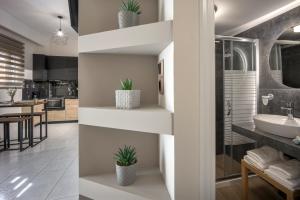 baño y cocina con estanterías blancas y fregadero en Myra Mare Suites by Estia en Amoudara Herakliou