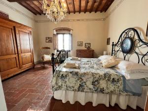 um quarto com uma cama e um lustre em Il Nido di Margherita em San Giovanni Valdarno