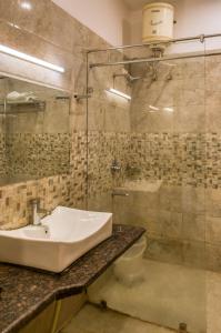 a bathroom with a sink and a shower and a toilet at Dee Fellows Riverside Resort in Garjia