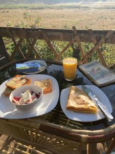 uma mesa com um prato de comida e uma tigela de torradas em Lotus Jewel Forest Camping em Sultan Bathery