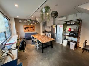 a kitchen and dining room with a wooden table at Guest House Matsu in Osaka