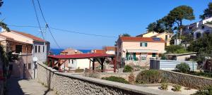 a city street with houses and a stone wall at Apartmani Valentina in Veli Lošinj