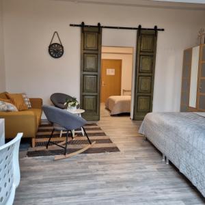 ein Wohnzimmer mit einem Bett und einem Sofa sowie ein Zimmer in der Unterkunft Pension Da Gigi in Oschersleben