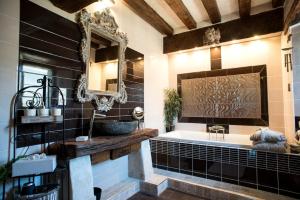 een badkamer met een bad, een spiegel en een wastafel bij Manoir de la Sénéchaussée de Lantiern in Arzal