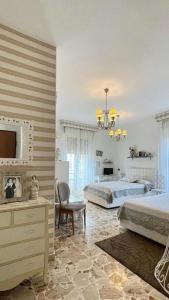 a bedroom with two beds and a chair and a dresser at Il Piccolo Attico in Caltagirone