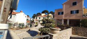 a city street with houses and potted plants at Apartmani Valentina in Veli Lošinj
