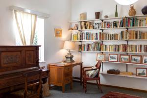 a room with a piano and a book shelf with books at Naos Farm Stay 