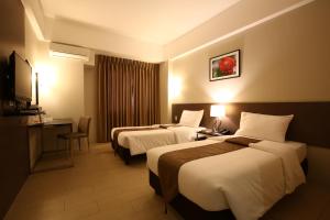 um quarto de hotel com duas camas e uma secretária em Sequoia Hotel em Manila