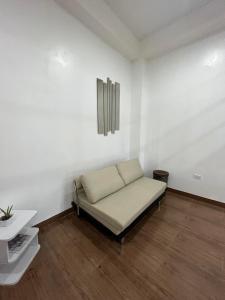 a bed in a room with white walls and wooden floors at ARJ Property Rental in Paringao La Union in Bauang