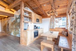 cocina con armarios de madera y mesa de madera en Dorfresort Kitzbühel by ALPS RESORTS, en Reith bei Kitzbühel