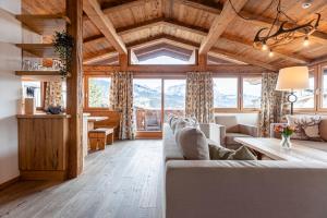 a living room with a couch and a table at Dorfresort Kitzbühel by ALPS RESORTS in Reith bei Kitzbühel