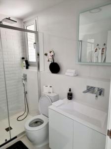 a white bathroom with a toilet and a sink at A modern villa with pool and sea view in Pilar de la Horadada