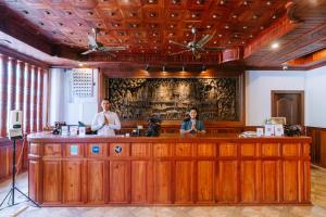 two men standing at a bar in a salon at V CROWN HOTEL in Battambang