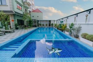 a swimming pool with a fish painted on the side of a building at V CROWN HOTEL in Battambang