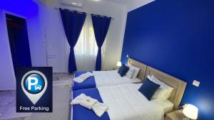 1 dormitorio azul con 2 camas y paredes azules en Patras Blue Suite, en Patra