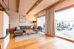 a living room with a couch and a table at Dorfresort Kitzbühel by ALPS RESORTS in Reith bei Kitzbühel