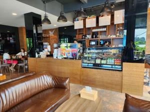 a restaurant with a leather couch in front of a counter at The Bedrooms Maeklong and Services Apartment in Samut Songkhram