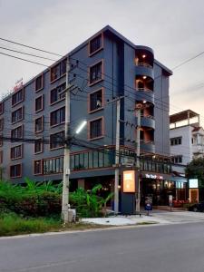 un grand bâtiment bleu sur le côté d'une rue dans l'établissement The Bedrooms Maeklong and Services Apartment, à Samut Songkhram