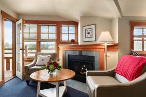 a living room with a fireplace and a couch and a table at La Conner Channel Lodge in La Conner