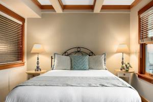 a bedroom with a bed with two lamps and two windows at La Conner Channel Lodge in La Conner