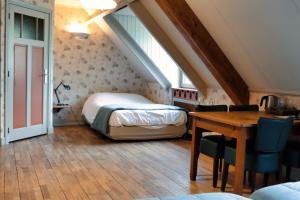 a bedroom with a bed and a desk in a attic at Buitengoed De Uylenburg in Delft