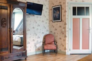 Pokój z lustrem, krzesłem i komodą w obiekcie Buitengoed De Uylenburg w mieście Delft