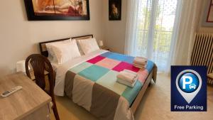 - une chambre avec un lit et une couverture colorée dans l'établissement Patras White Castle, à Patras