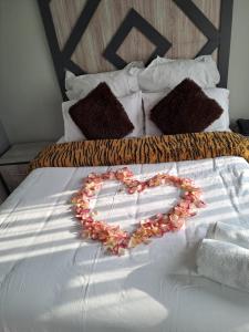 a heart made out of flowers on a bed at National Lodge in Benoni +82 photos