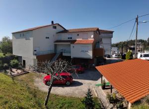 a red car parked in front of a house at Hostal Nuevo Alonso in Bembribe