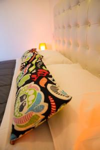 a bed with a colorful pillow on it at Villa Pandora - Angela & Michali in Maleme