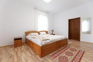 Schlafzimmer mit einem Bett, einem Fenster und einem Teppich in der Unterkunft Pensiunea Cașoca-Cascadă in Siriu