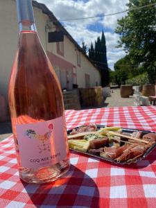 uma garrafa de vinho sentada numa mesa com uma bandeja de comida em Maison de Maitre for 10 people in the heart of the vineyard em Badens
