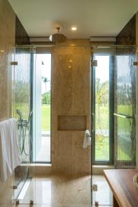 baño con ducha y puerta de cristal en Laguna homes en Thalang