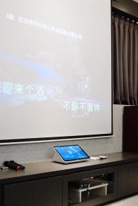 una tablet sentada en una mesa frente a una pantalla en 安平包棟民宿 - 尋雨 - 台南民宿Ktv影音室限包棟使用 en Tainan