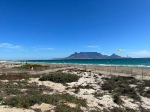 a beach with people flying kites in the ocean at Private Cottage on Alamein in Cape Town