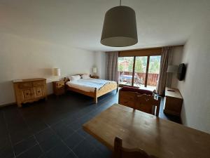 a bedroom with a bed and a table and a dining room at Mountain River Appart in Val dʼIlliez