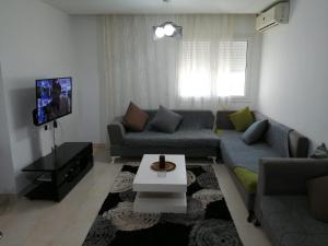 a living room with a couch and a tv at EZZAYATINE in Tunis